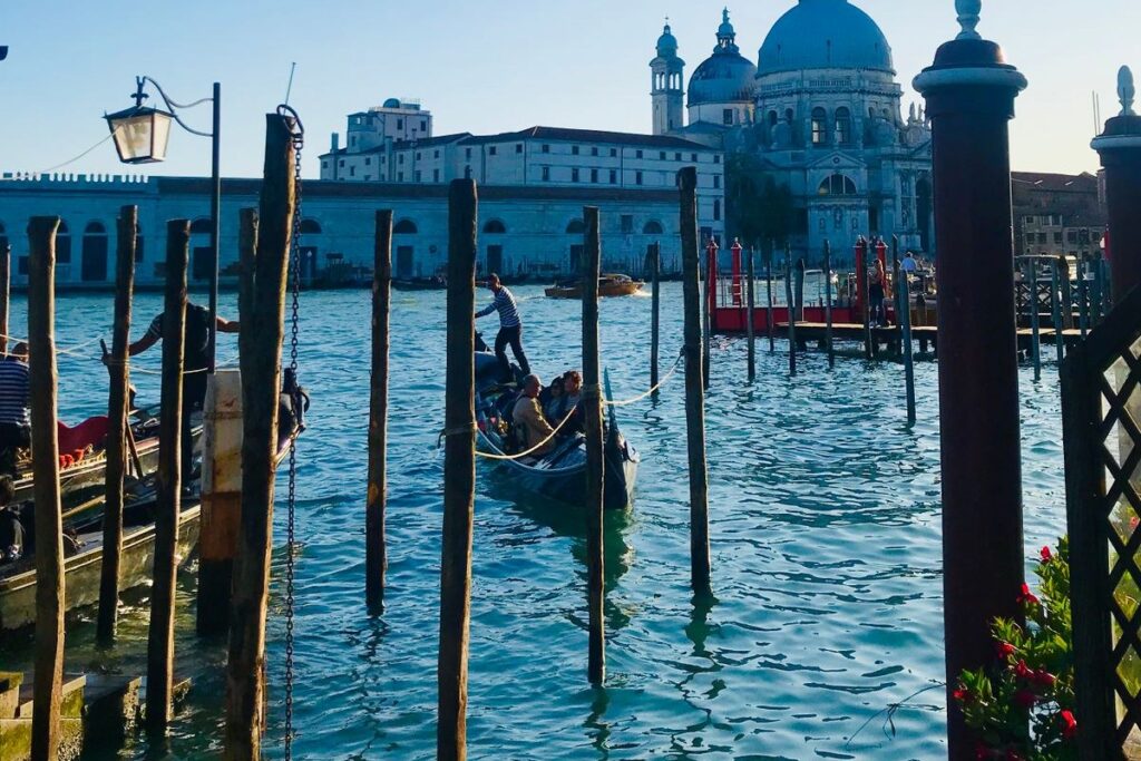 Il Canal Grande a Venezia visto da una riva, con una gondola e la Basilica della Salute sullo sfondo